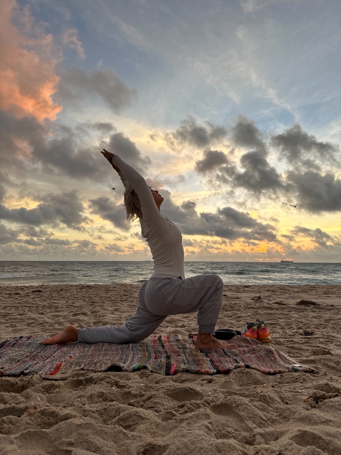 Gabriella stretching on the beach at sunrise